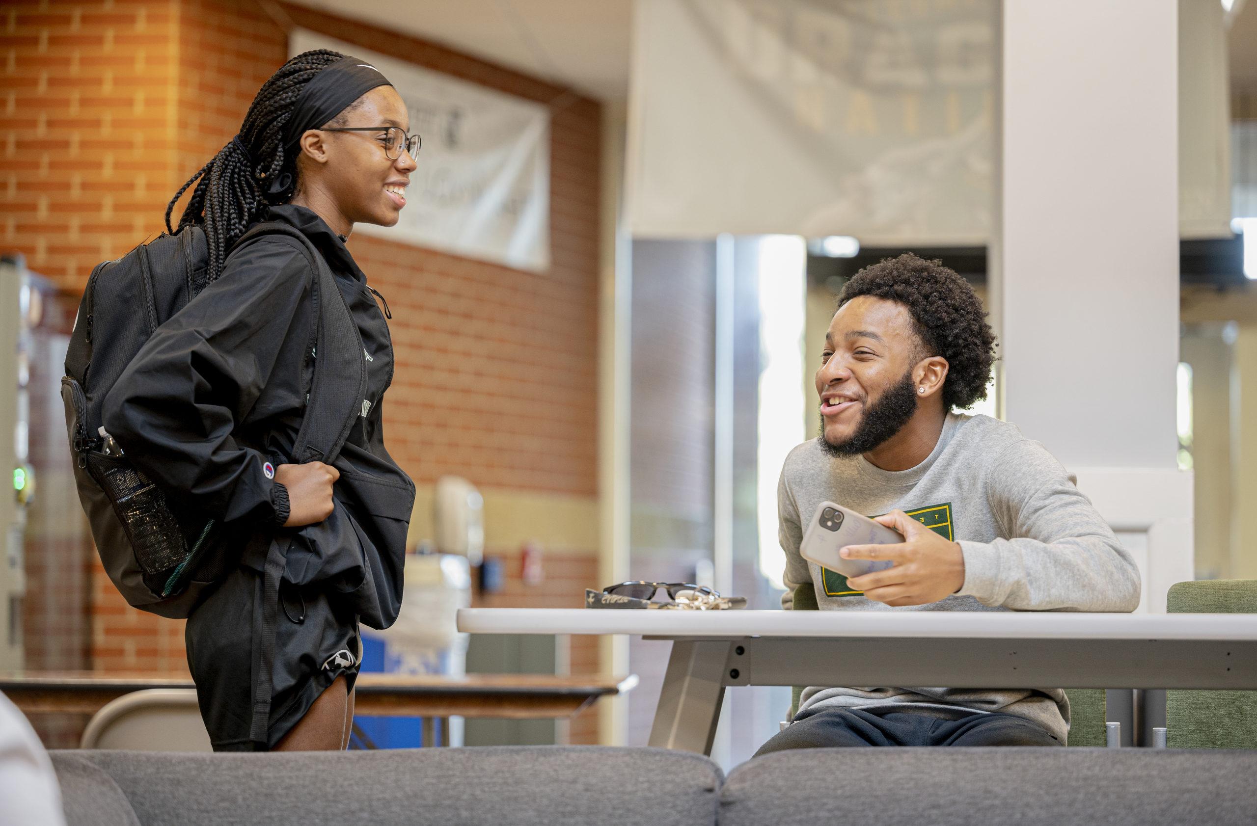 Two smiling students talking